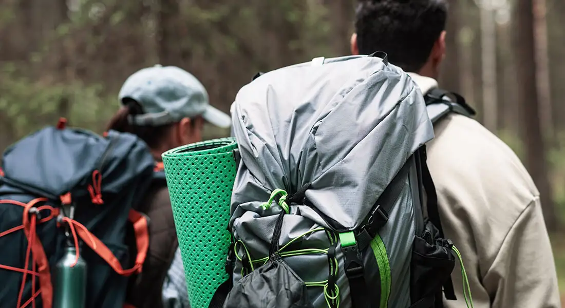Senderistas con mochilas recorriendo un bosque