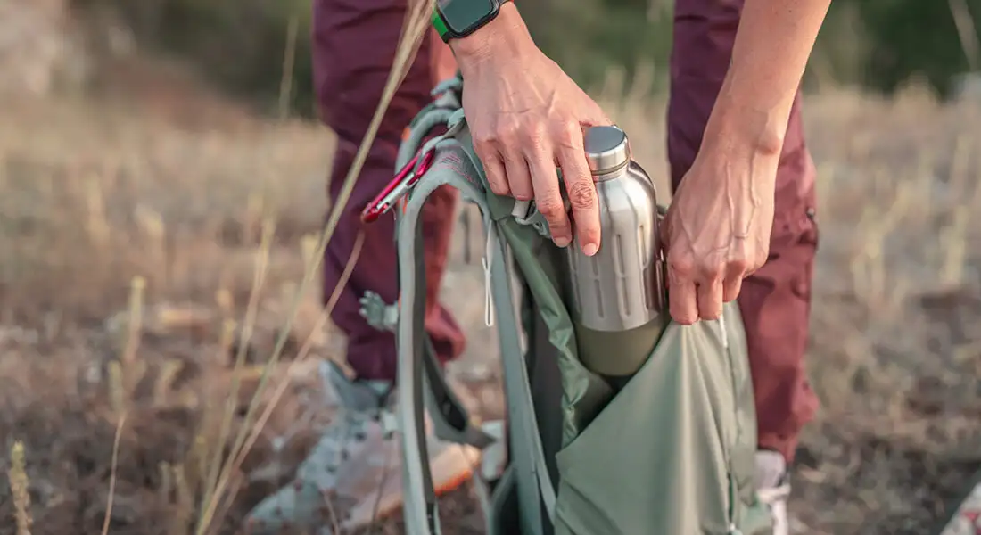 Preparación de una mochila y botella de agua para una caminata