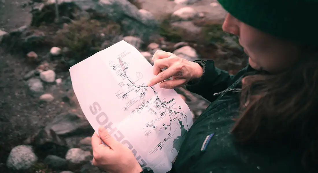 Viajera consultando un mapa para planificar una ruta de senderismo