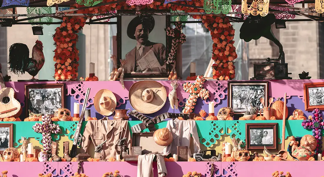Altar de Día de Muertos con fotografías, flores y papel picado